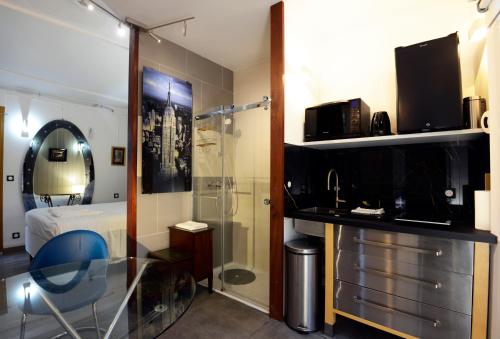 a hotel room with a shower and a bedroom at Hotel de la muraille de sens in Sens