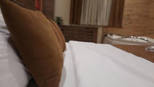 a bed with white sheets and pillows in a room at Stan na Dan Apartman D Lux Jacuzzi in Kragujevac