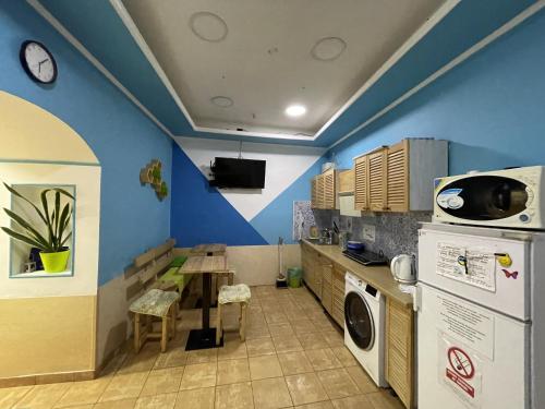 une cuisine avec une table et un mur bleu dans l'établissement AntiHostel Forrest, à Lviv