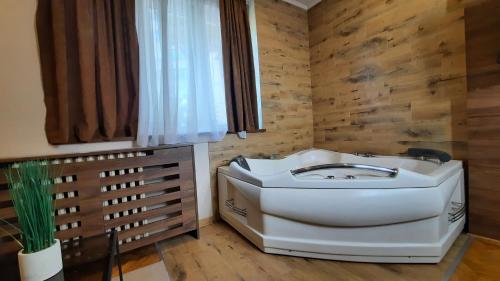 a bathroom with a white sink and a window at Stan na Dan Apartman D Lux Jacuzzi in Kragujevac