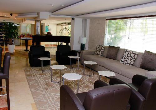 a living room with a couch and a piano at Country International Hotel in Barranquilla