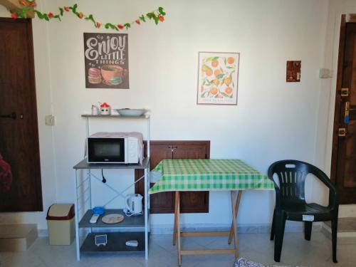 パレルモにあるRoom holiday "al centro storico"のキッチン(テーブル、電子レンジ、椅子付)