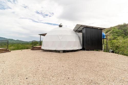 a large white dome building on top of a hill at Glamping en Playa Potrero in Potrero
