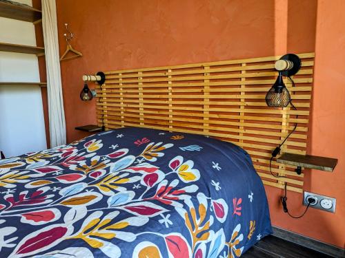 a bedroom with a bed with a floral bedspread at Studio à la campagne au bout du lac d'Annecy in Doussard
