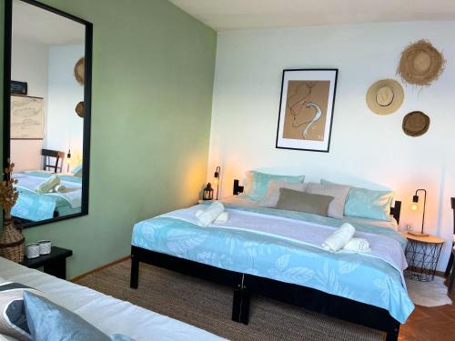 een slaapkamer met een groot blauw bed en een spiegel bij Beach House Hvar in Zastražišće