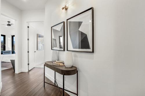 a living room with a table and two framed pictures on the wall at ZION TREASURE - RUBY at Copper Rock! in Hurricane
