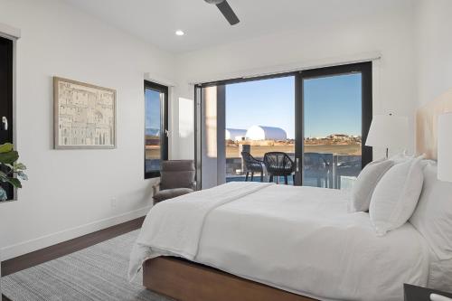 a white bedroom with a large bed and a balcony at ZION TREASURE - RUBY at Copper Rock! in Hurricane