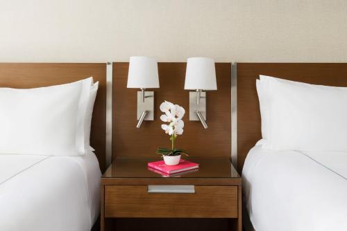 Cette chambre d'hôtel dispose de 2 lits et d'une table fleurie. dans l'établissement The Altair Bay Harbor Hotel, à Miami Beach