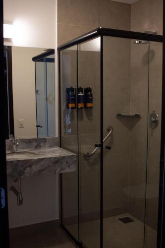 a bathroom with a glass shower and a sink at Comfort Hotel Presidente Prudente in Presidente Prudente