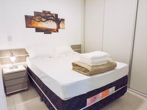 a bedroom with a bed with towels on it at Encantador Refúgio Completo e Bem Localizado in Campos dos Goytacazes