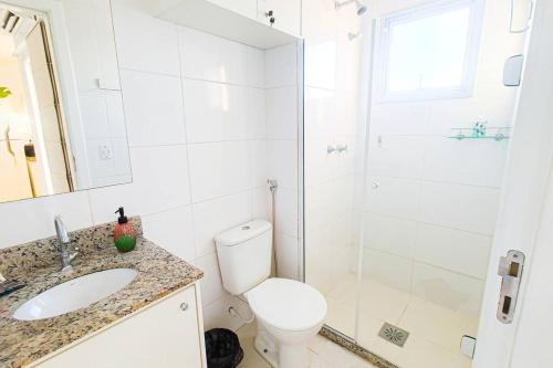 a white bathroom with a toilet and a shower at Encantador Refúgio Completo e Bem Localizado in Campos dos Goytacazes