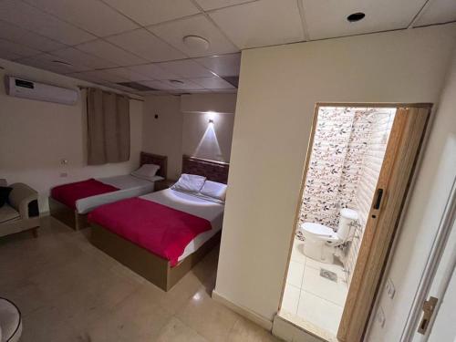 ein Hotelzimmer mit 2 Betten und einem Fenster in der Unterkunft El jawhra house in Kairo