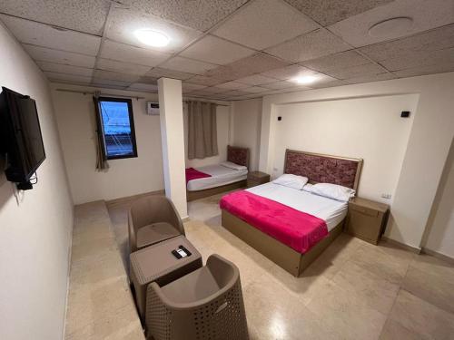 ein Schlafzimmer mit einem Bett und einem Stuhl in einem Zimmer in der Unterkunft El jawhra house in Kairo