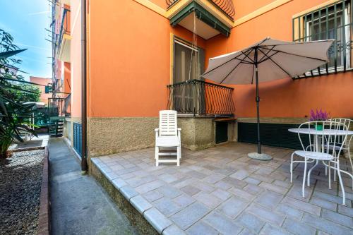 a patio with a table and an umbrella and chairs at Maison d' Ofelia in Chiavari