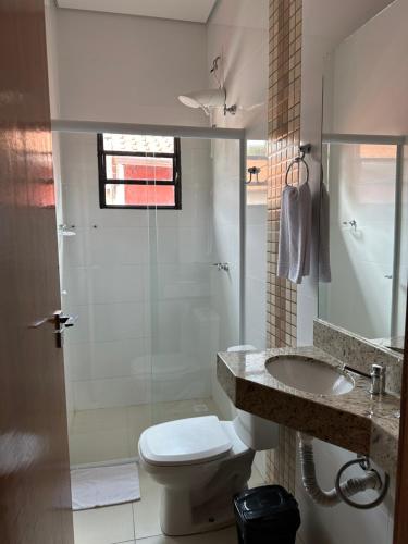 a bathroom with a toilet and a sink and a shower at Shafira Hotel in Limeira