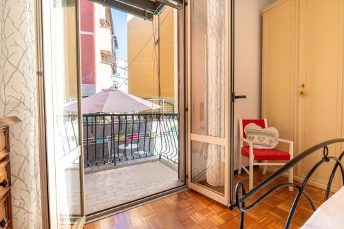 a glass door leading to a balcony with a red chair at Maison d' Ofelia in Chiavari