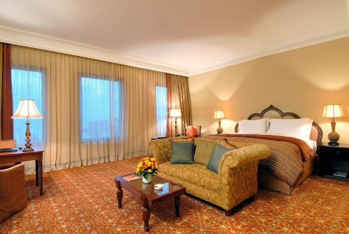 a hotel room with a bed and a couch at Djibouti Palace Kempinski in Djibouti