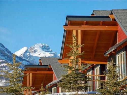 a resort building with a mountain in the background at Pinnacle Ridge Condos by Fernie Central Reservations in Fernie
