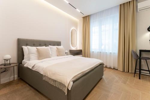 a bedroom with a large bed and a window at Olive Apartments in Belgrade