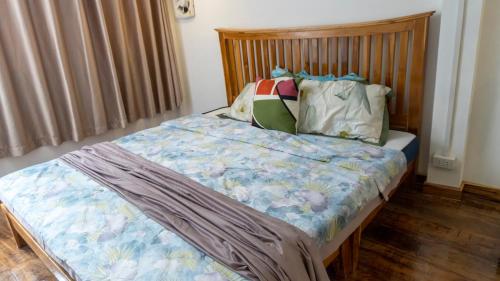 a bedroom with a bed with a wooden headboard at La Casa De Jardin in Luang Prabang
