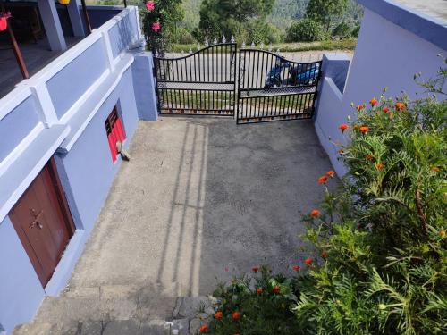 a gate on the side of a building with flowers at The Heavens in Almora