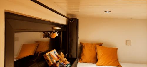 Litera negra con almohadas de color naranja en un dormitorio en Tiny House 14 - Sollberg en Salzhemmendorf
