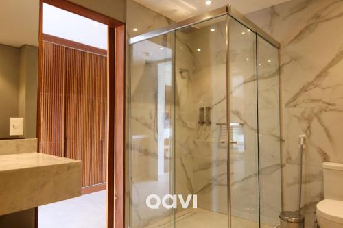 a glass shower in a bathroom with a toilet at Qavi - Luxo Rua Principal de Pipa #ÎledePipa in Pipa