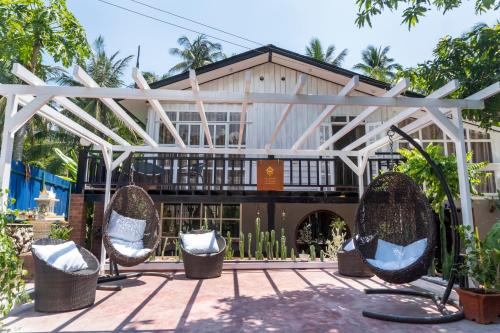 a building with two chairs in front of it at La Casa De Jardin in Luang Prabang