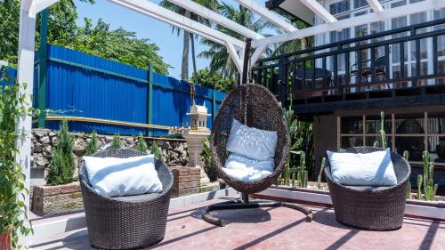 two chairs with pillows sitting on a patio at La Casa De Jardin in Luang Prabang