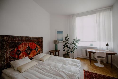 Schlafzimmer mit einem Bett, einem Tisch und einem Fenster in der Unterkunft Space Age Residence in Łódź