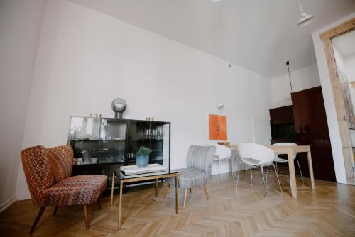 ein Wohnzimmer mit Stühlen und einem Tisch sowie eine Küche in der Unterkunft Space Age Residence in Łódź