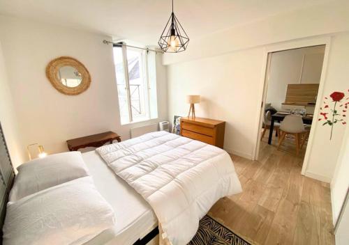 a bedroom with a large bed and a table at A l'Université - Poitiers - La Conciergerie. in Poitiers