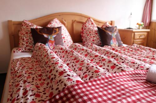 two beds with red and white sheets and pillows at Pension Leopoldine in Hallstatt