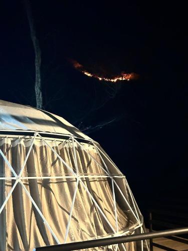 a white dome with a city in the background at night at Glamping en Playa Potrero in Potrero