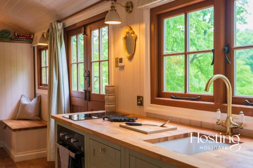 a kitchen with a sink and some windows at Red Kite Retreat - Bluebell - Shepherds Hut 1 in Henley on Thames