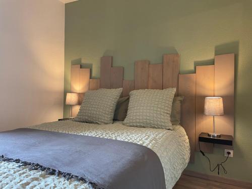 een slaapkamer met een bed met een houten hoofdeinde bij Studio Ma Préférence in Horbourg