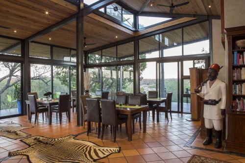a man standing in a room with tables and chairs at Greenfire Game Lodge in Balule Game Reserve