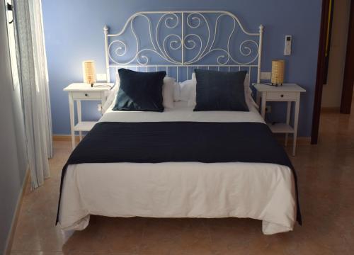 a large bed with a blue headboard and two tables at El Charco Azul in San Andres y Sauces