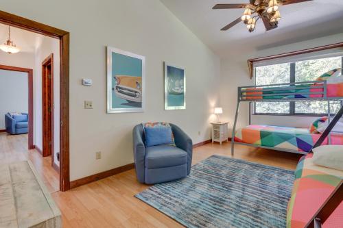 a living room with a blue chair and a bed at Riverfront DeLand Home with Pool, Near Daytona! in DeLand