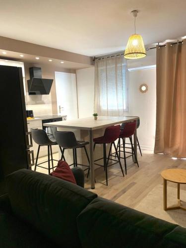 a living room with a table and chairs and a kitchen at L'oasis aux portes de Toulouse in Muret