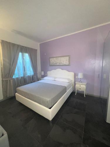 a bedroom with a large white bed and a window at Acquamarina Luxury Rooms in Budoni