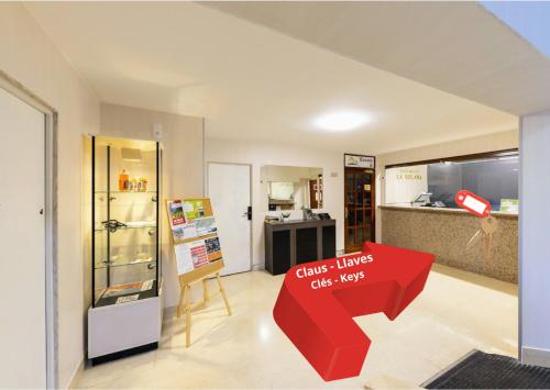 a room with a red table and a kitchen at La Solana Apartaments & Spa in Encamp