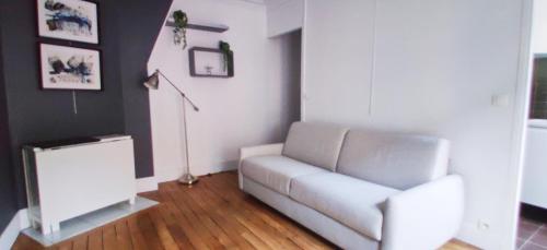salon z białą kanapą i lampą w obiekcie Luxueux appartement Paris 17 w Paryżu