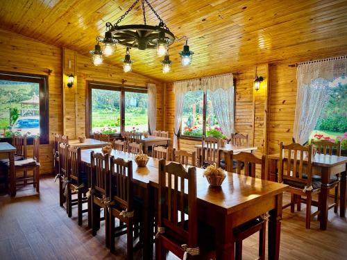 Pousada Rural Vista Alegre في بوم جارديم دا سيرا: غرفة طعام كبيرة مع طاولات وكراسي خشبية