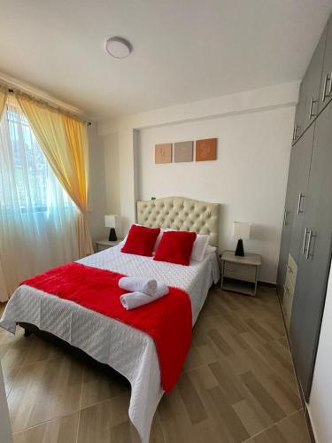 1 dormitorio con 1 cama grande con almohadas rojas en Moderno apto familiar piso 2 en Santa Rosa de Cabal
