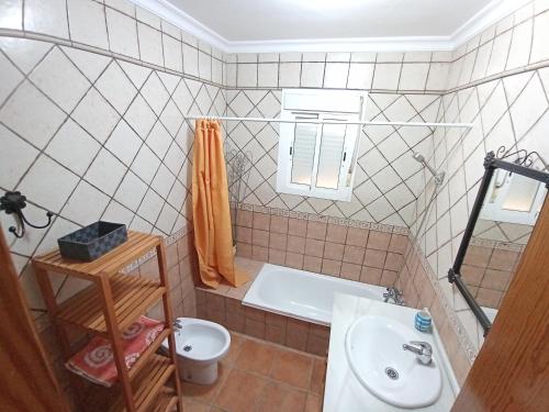 La salle de bains est pourvue d'une baignoire, d'un lavabo et de toilettes. dans l'établissement Casa Familiar 150 Metros de la Playa El Palmar, à El Palmar