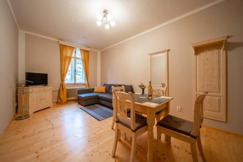 a living room with a table and a couch at Zámeček Waldsteinovo Zátiší in Svatoslav