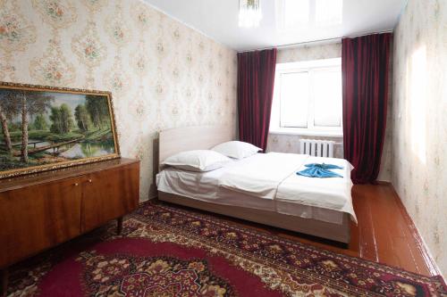 a small bedroom with a bed and a window at Самара in Petropavlovsk