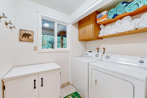 a white laundry room with a washer and dryer at Heavenly Ski Lodge in Welches