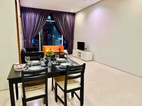 uma sala de jantar com uma mesa e cortinas roxas em Soho Suites Klcc By Sweet Home em Kuala Lumpur